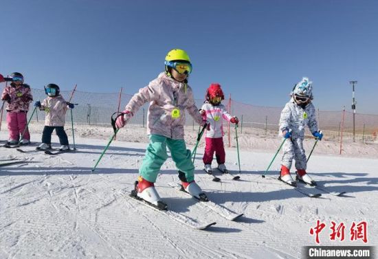 图为小学生体验滑雪。